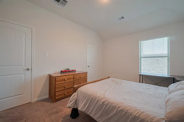 a bedroom with a bed and a dresser