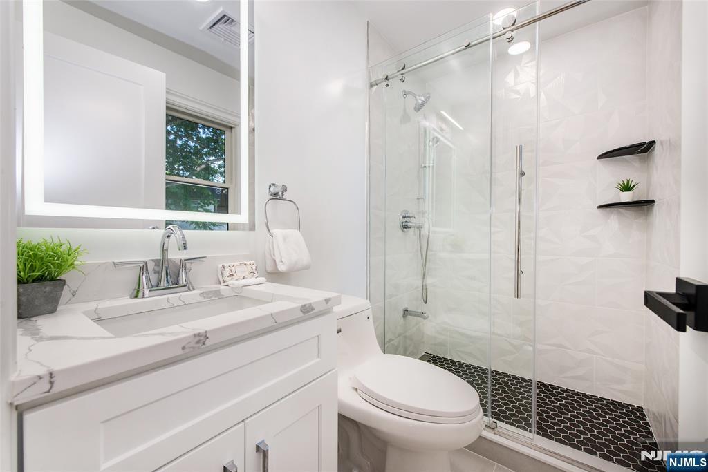 145 Grove Street Mahwah, NJ 07430 - Photo 16 of 30 a bathroom with a sink toilet vanity and shower