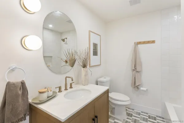 a bathroom with a sink vanity mirror and toilet