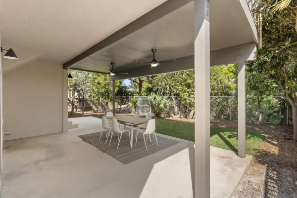 a view of a chair and table in backyard of the house