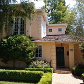 a view of house with a yard and potted plants