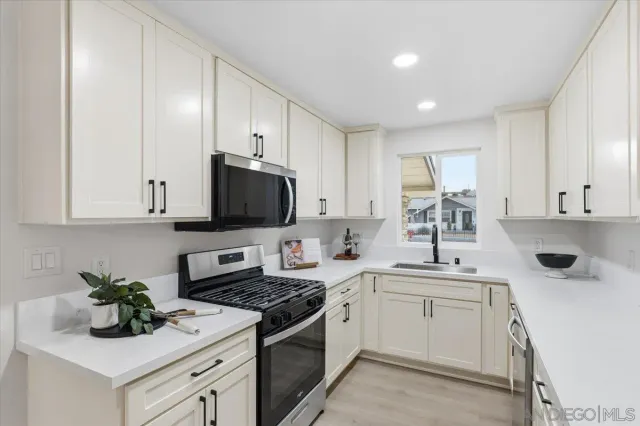 a kitchen with a sink stove top oven and cabinets