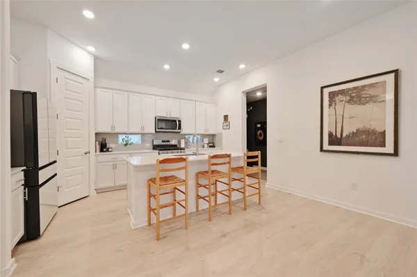 a kitchen with white cabinets and refrigerator