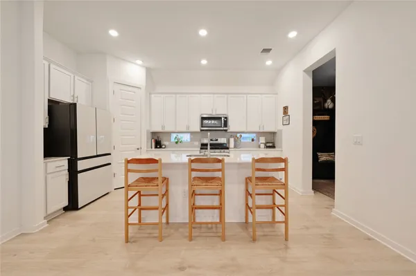 a kitchen with a refrigerator and a dining table