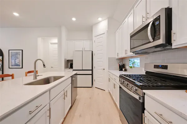 a kitchen with stainless steel appliances granite countertop a sink stove and cabinets