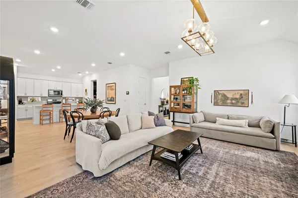 a living room with furniture kitchen view and a table