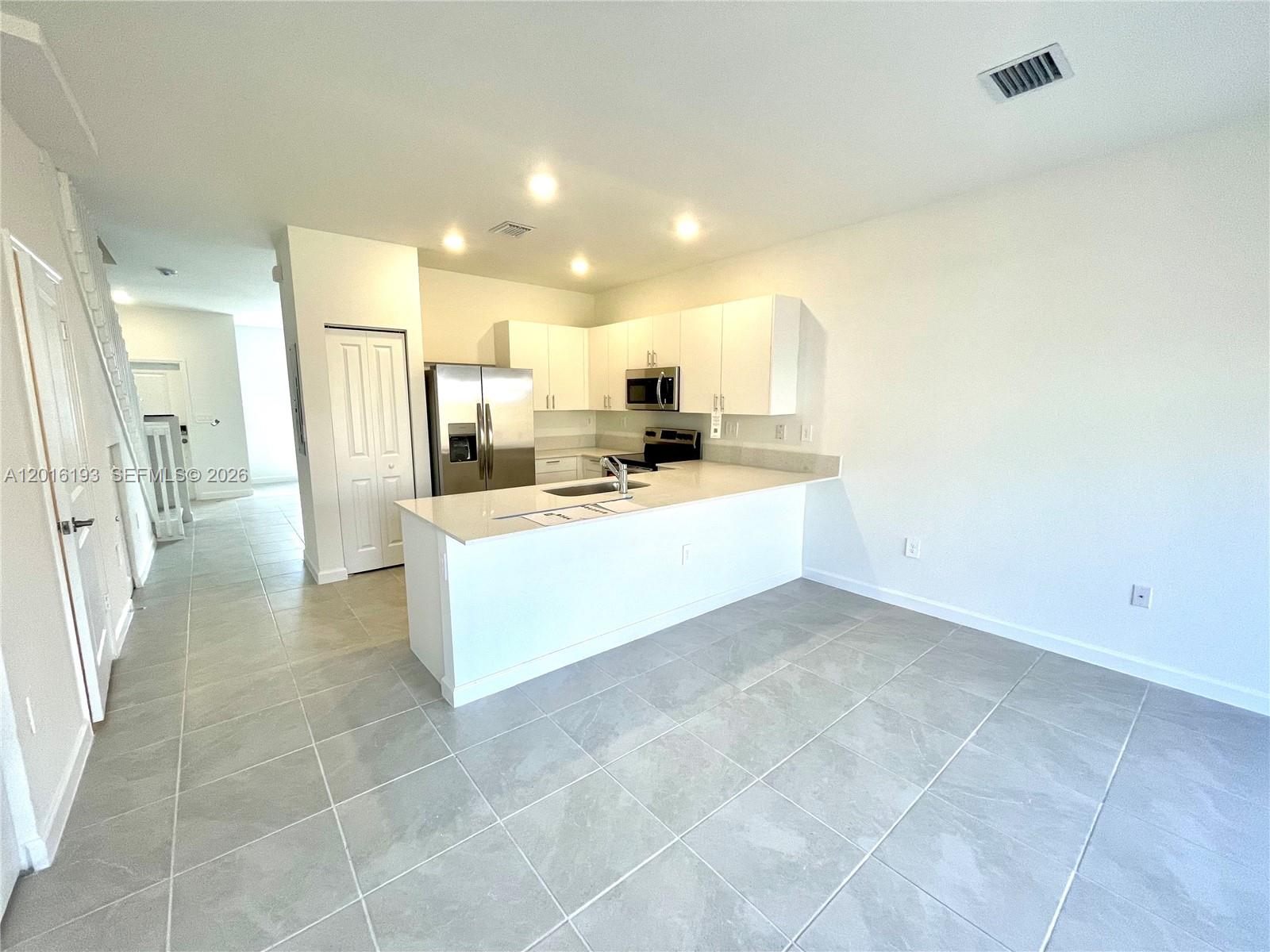 11737 Southwest 245 Terrace Homestead, FL 33032 - Photo 5 of 16 a large white kitchen with a sink and cabinets