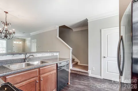 a kitchen with stainless steel appliances granite countertop a sink and a refrigerator