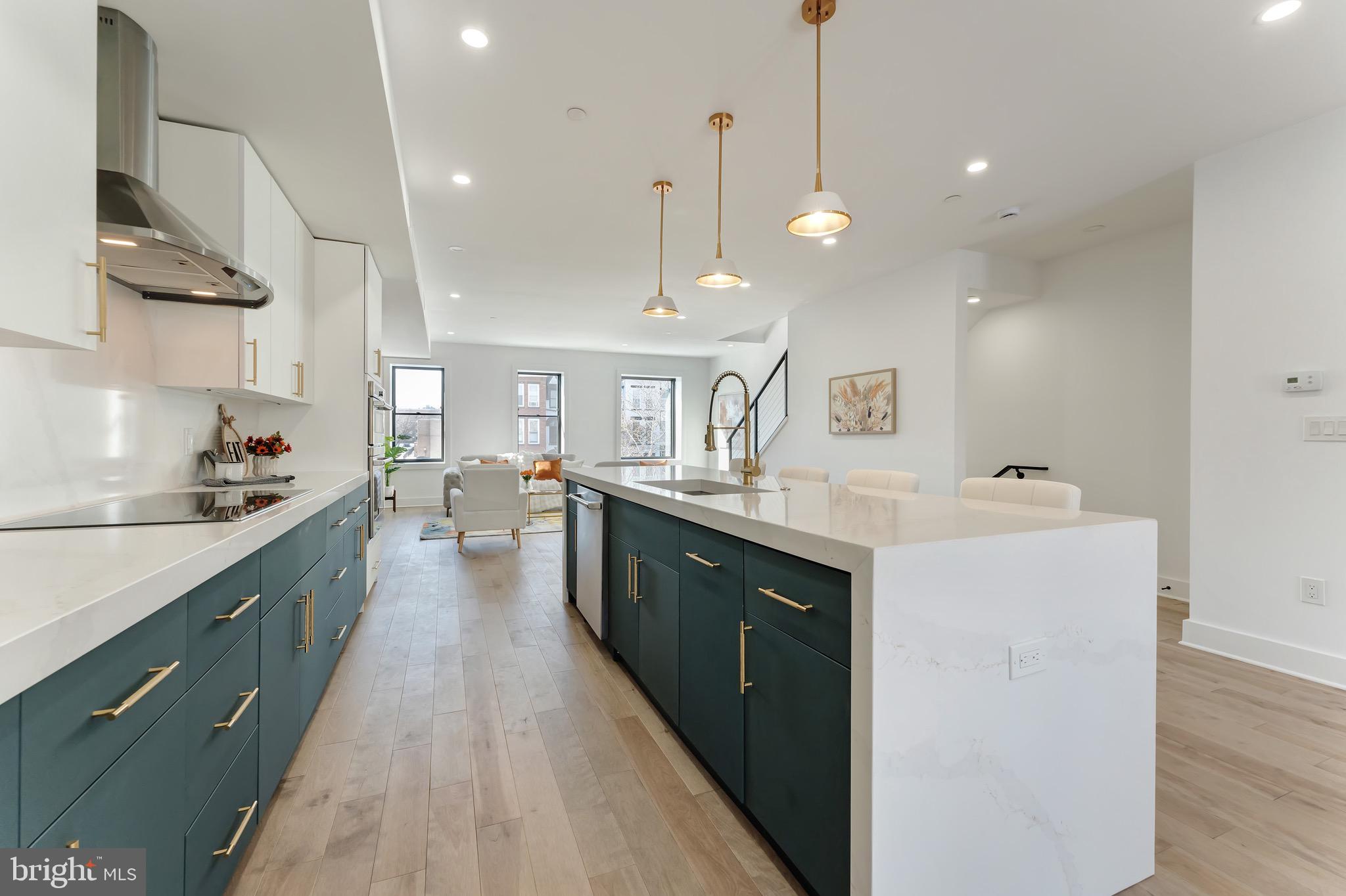 3009 13th Street Northwest, Unit 2 Washington, DC 20009 - Photo 10 of 44 a large kitchen with kitchen island a sink a counter space and stainless steel appliances
