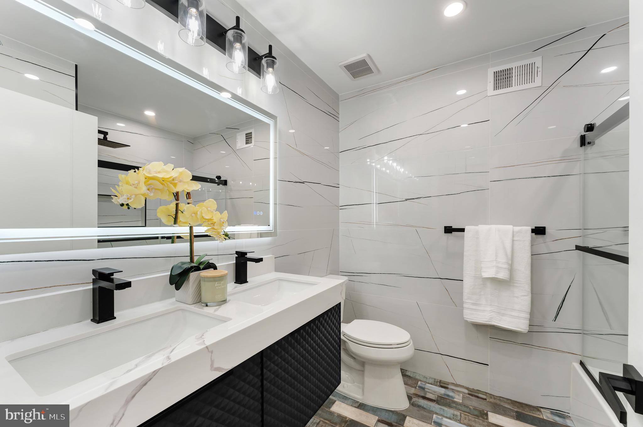 3009 13th Street Northwest, Unit 2 Washington, DC 20009 - Photo 26 of 44 a bathroom with a sink toilet a mirror and shower