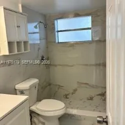 a white toilet sitting next to a bathroom sink