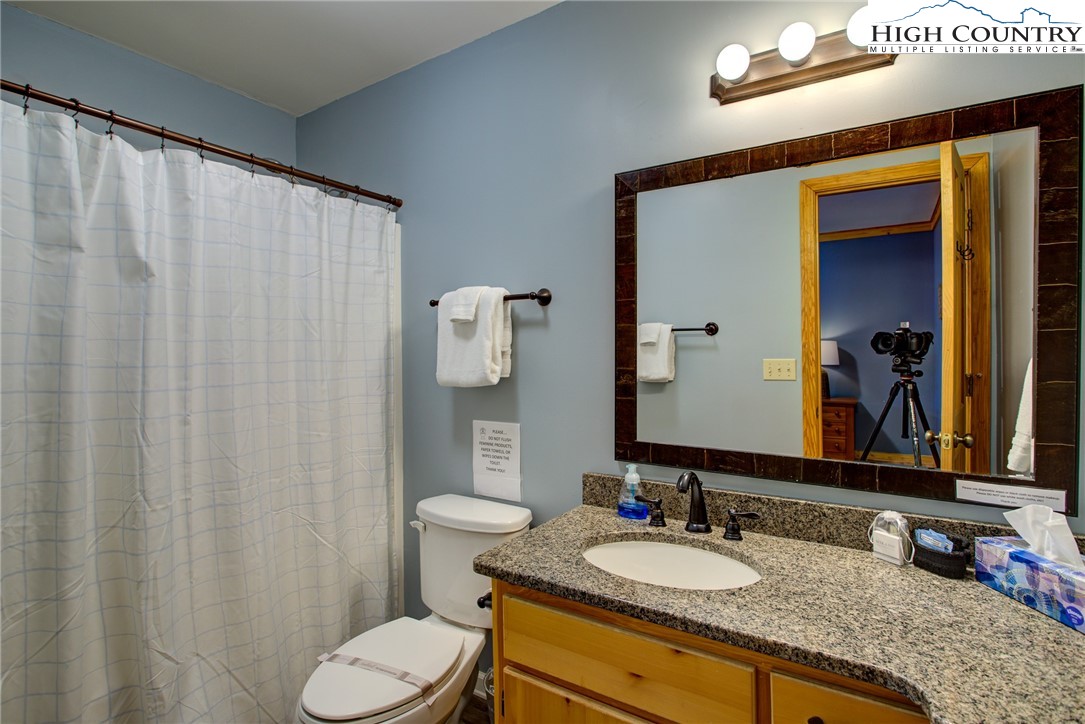 1643 Buck Mountain Road Purlear, NC 28665 - Photo 11 of 33 a bathroom with a granite countertop sink and a mirror with toilet