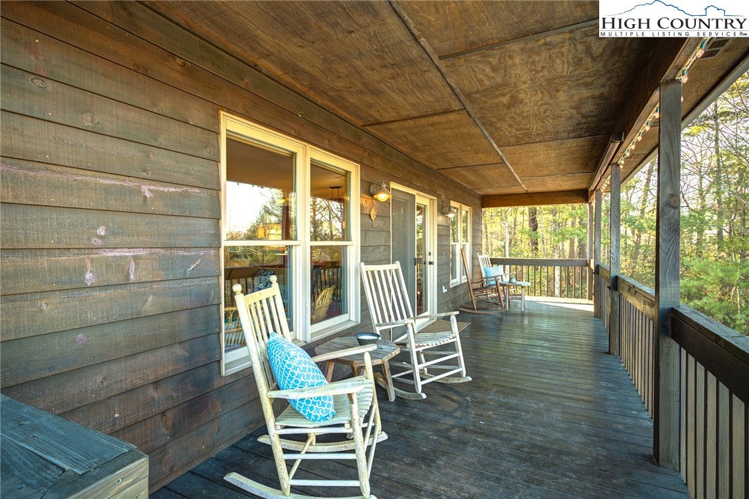 1643 Buck Mountain Road Purlear, NC 28665 - Photo 13 of 33 a view of a porch with chairs and floor to ceiling window