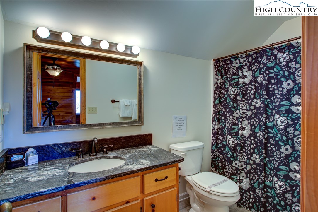1643 Buck Mountain Road Purlear, NC 28665 - Photo 20 of 33 a bathroom with a granite countertop double vanity sink mirror and toilet