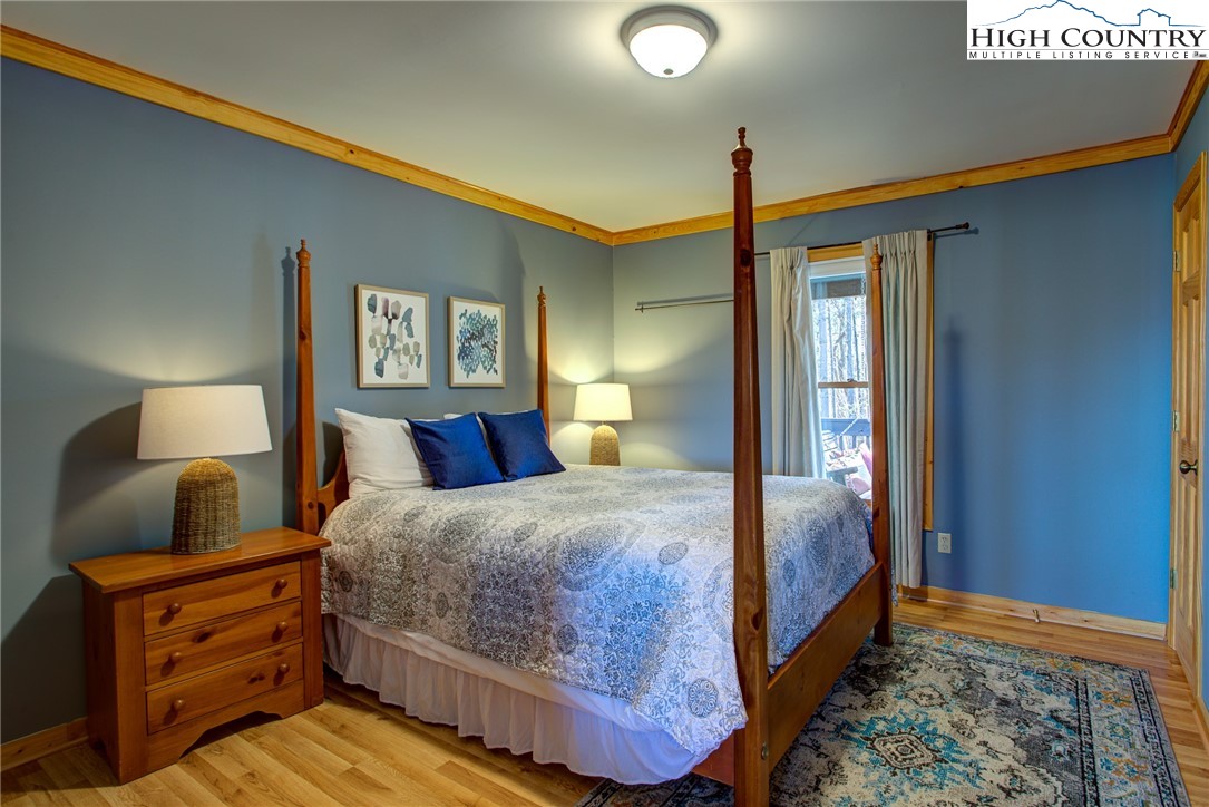 1643 Buck Mountain Road Purlear, NC 28665 - Photo 10 of 33 a bedroom with a bed and wooden floor
