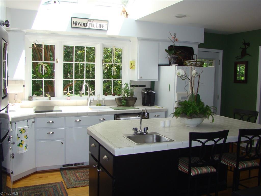 3614 Pinetop Road Greensboro, NC 27410 - Photo 11 of 30 Skylights and large windows flood this kitchen with natural light. Door from kitchen steps out onto brick patio.