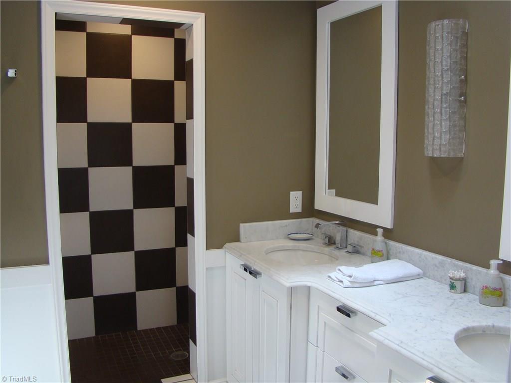 3614 Pinetop Road Greensboro, NC 27410 - Photo 15 of 30 Updated and modern walk in shower with brown and white checkerboard pattern.