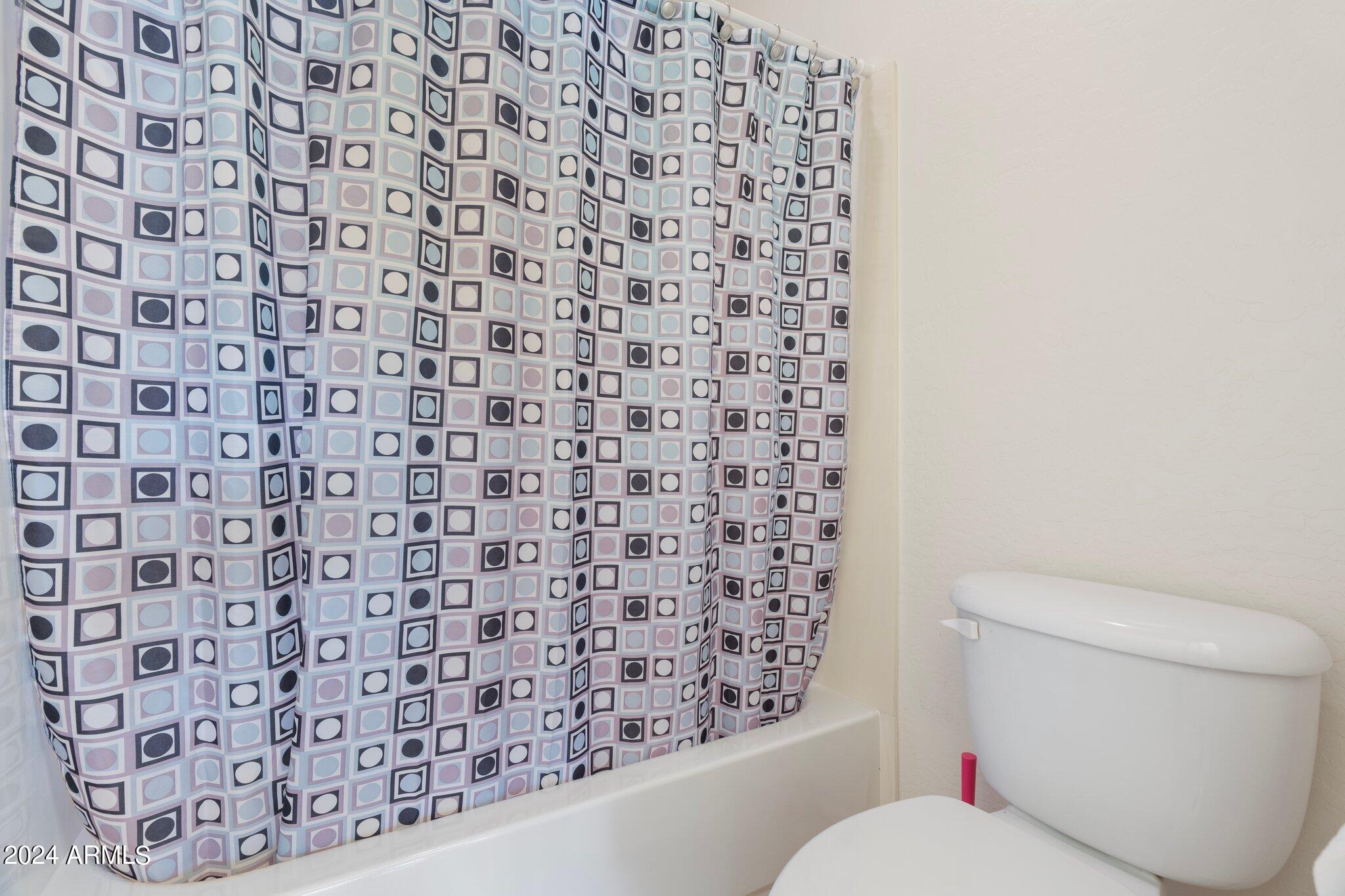 4427 West Summerside Road Laveen, AZ 85339 - Photo 21 of 72 a bathroom with a toilet and a shower curtain