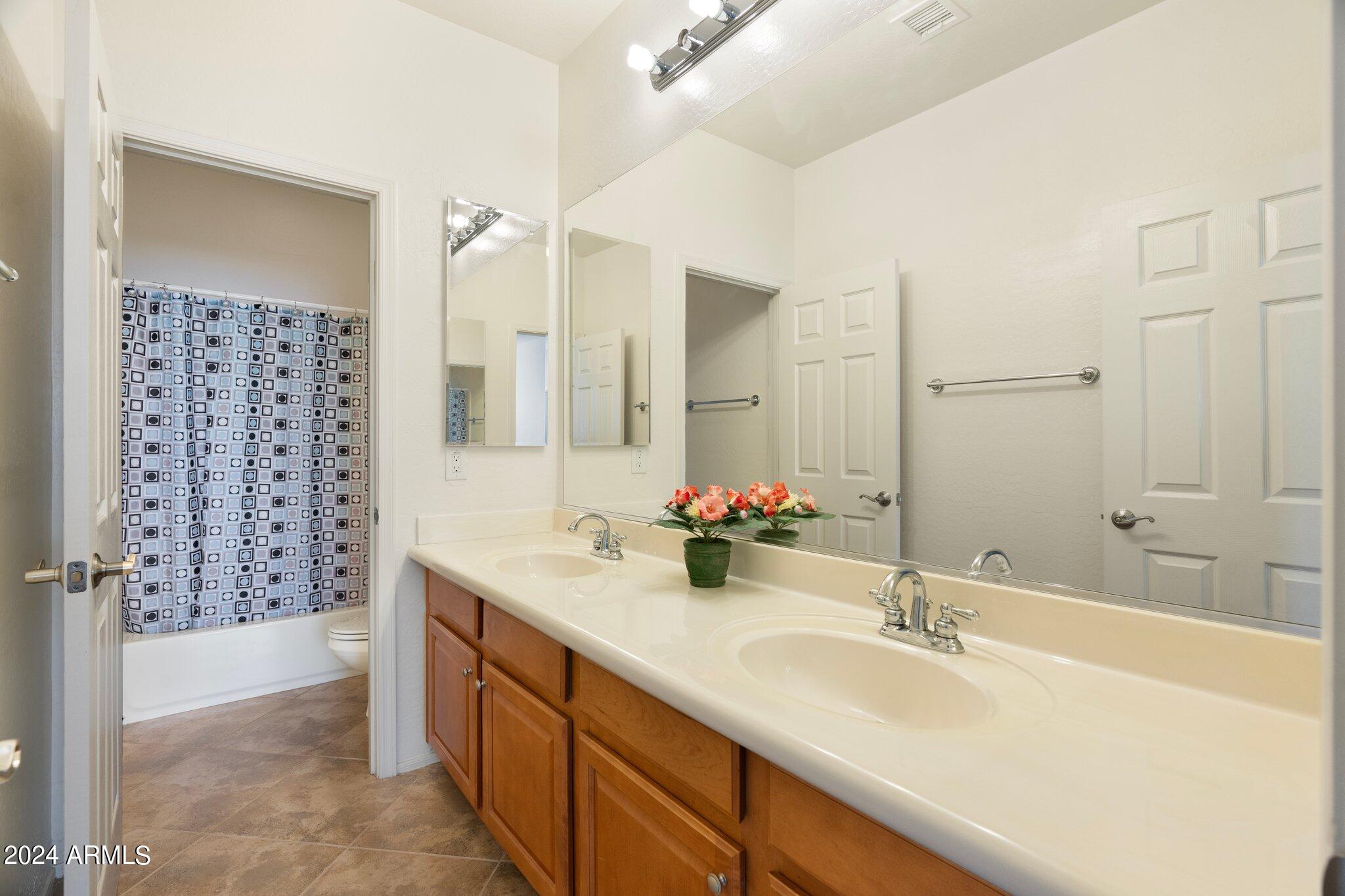 4427 West Summerside Road Laveen, AZ 85339 - Photo 22 of 72 a bathroom with a double vanity sink mirror double and shower