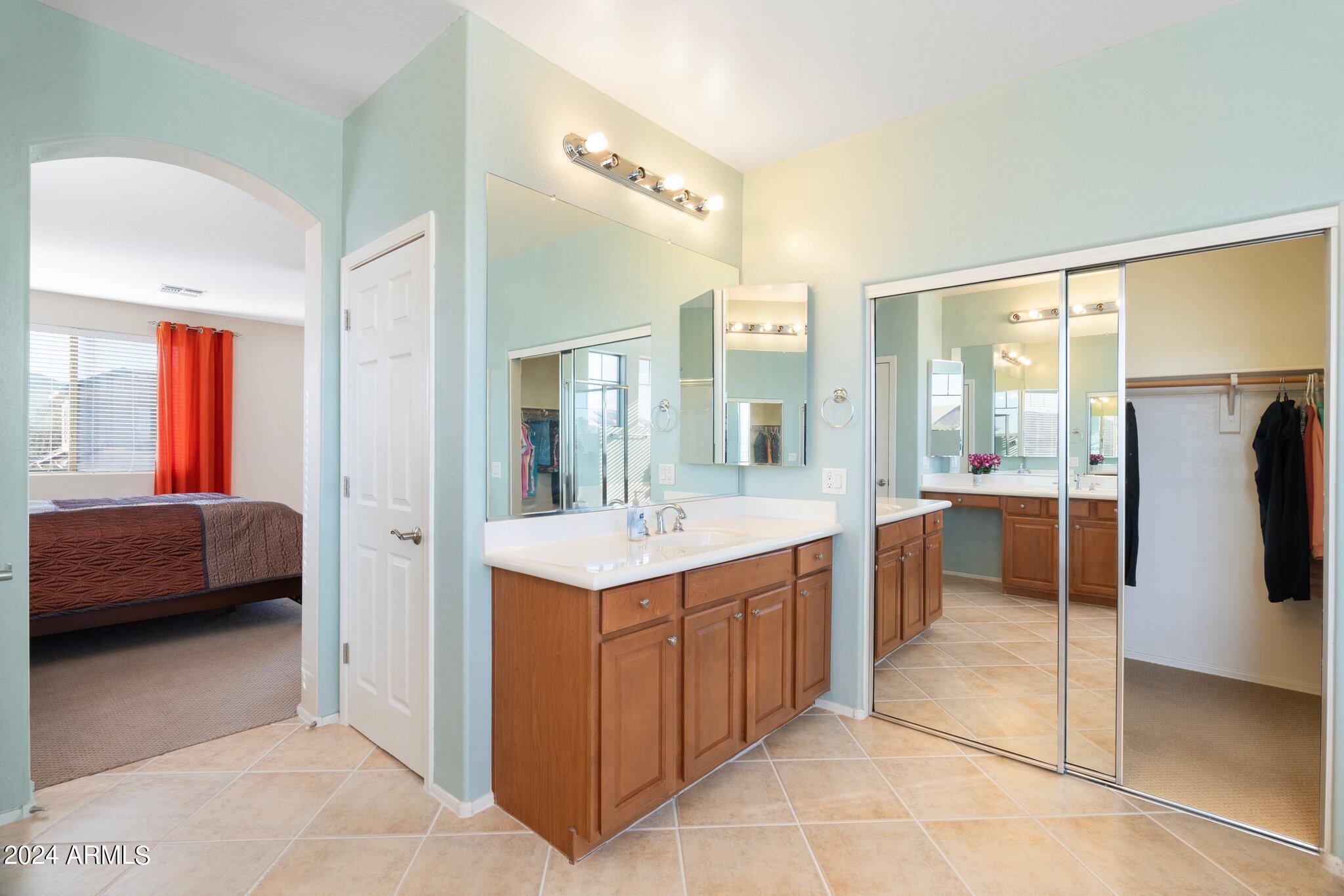 4427 West Summerside Road Laveen, AZ 85339 - Photo 33 of 72 a large bathroom with a double vanity sink a large mirror and a bathtub