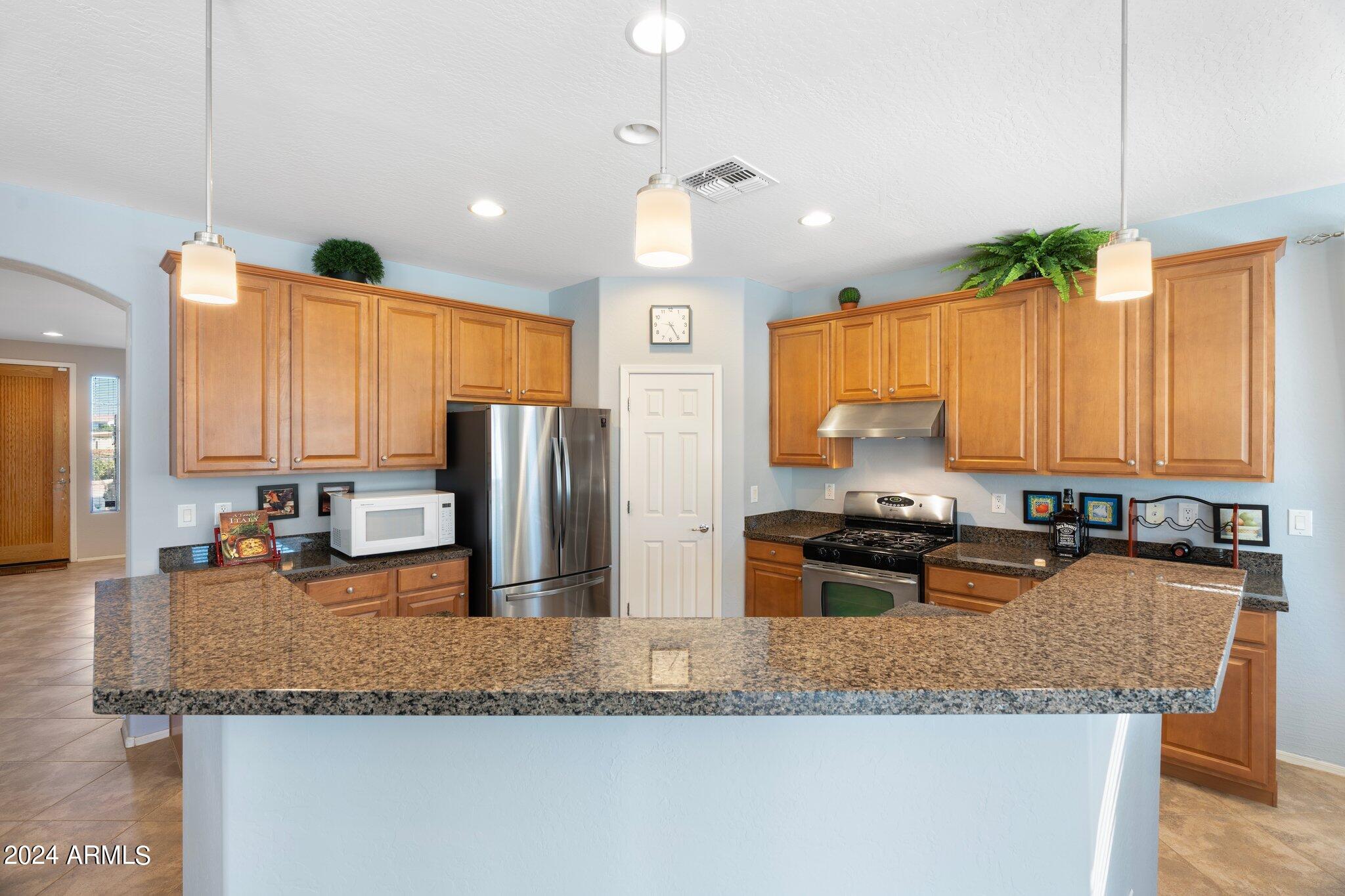 4427 West Summerside Road Laveen, AZ 85339 - Photo 8 of 72 a kitchen with granite countertop a sink a counter top space and stainless steel appliances