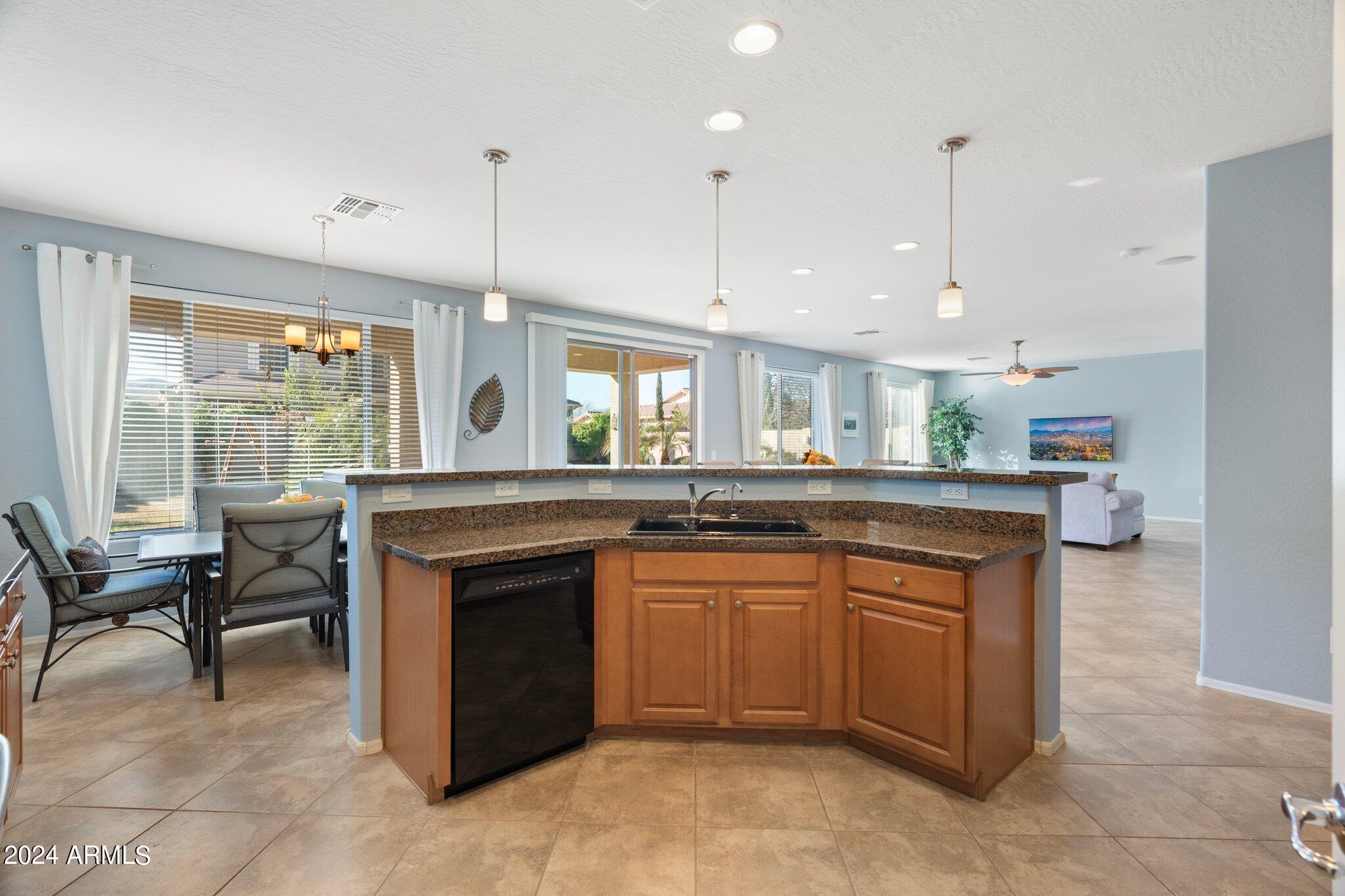 4427 West Summerside Road Laveen, AZ 85339 - Photo 9 of 72 a kitchen with a sink a stove a dining table and chairs