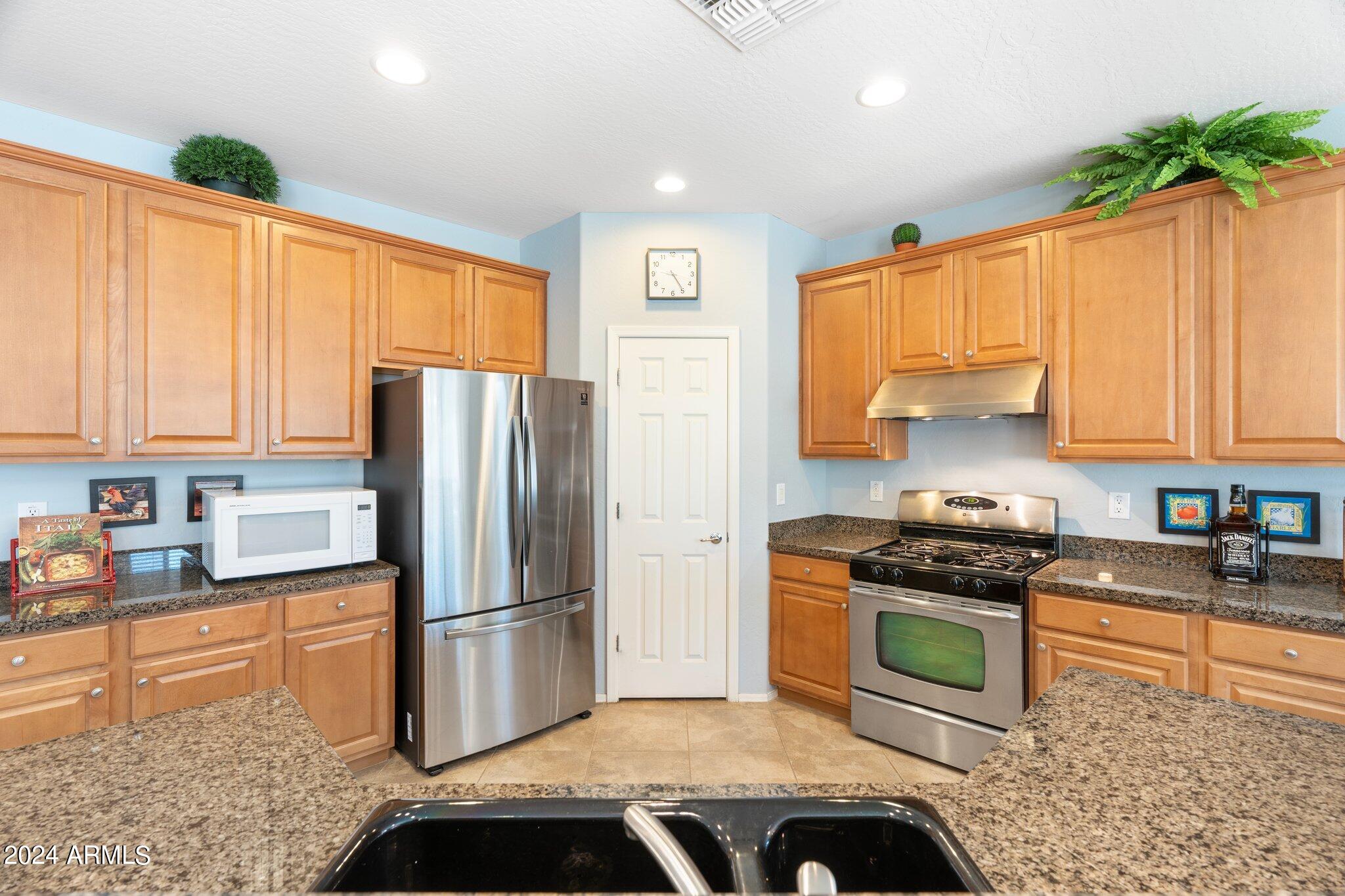 4427 West Summerside Road Laveen, AZ 85339 - Photo 10 of 72 a kitchen with stainless steel appliances granite countertop a stove a refrigerator and a sink