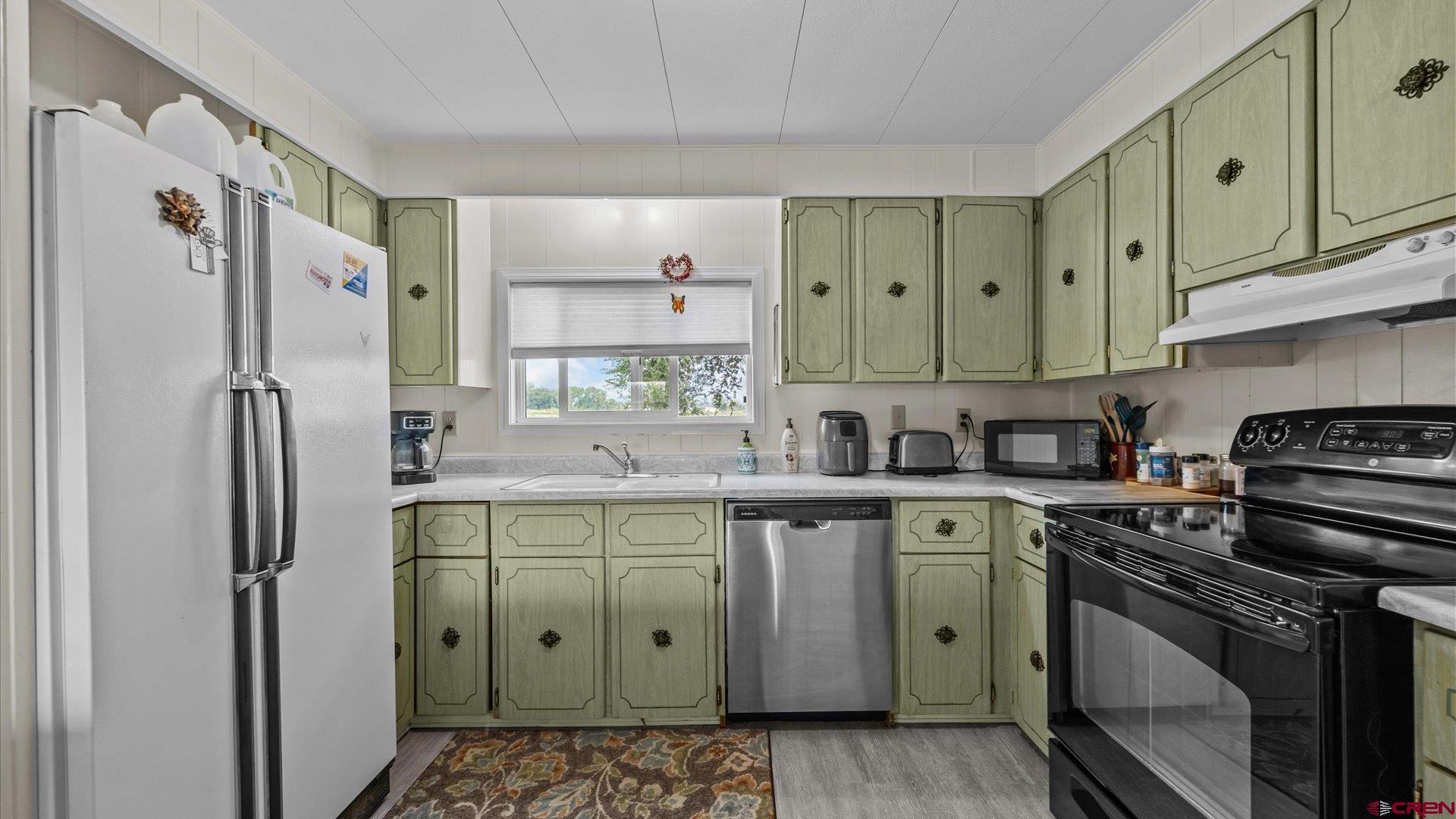 14860 Deer Run Road Delta, CO 81416 - Photo 13 of 33 a kitchen with stainless steel appliances a stove sink and refrigerator
