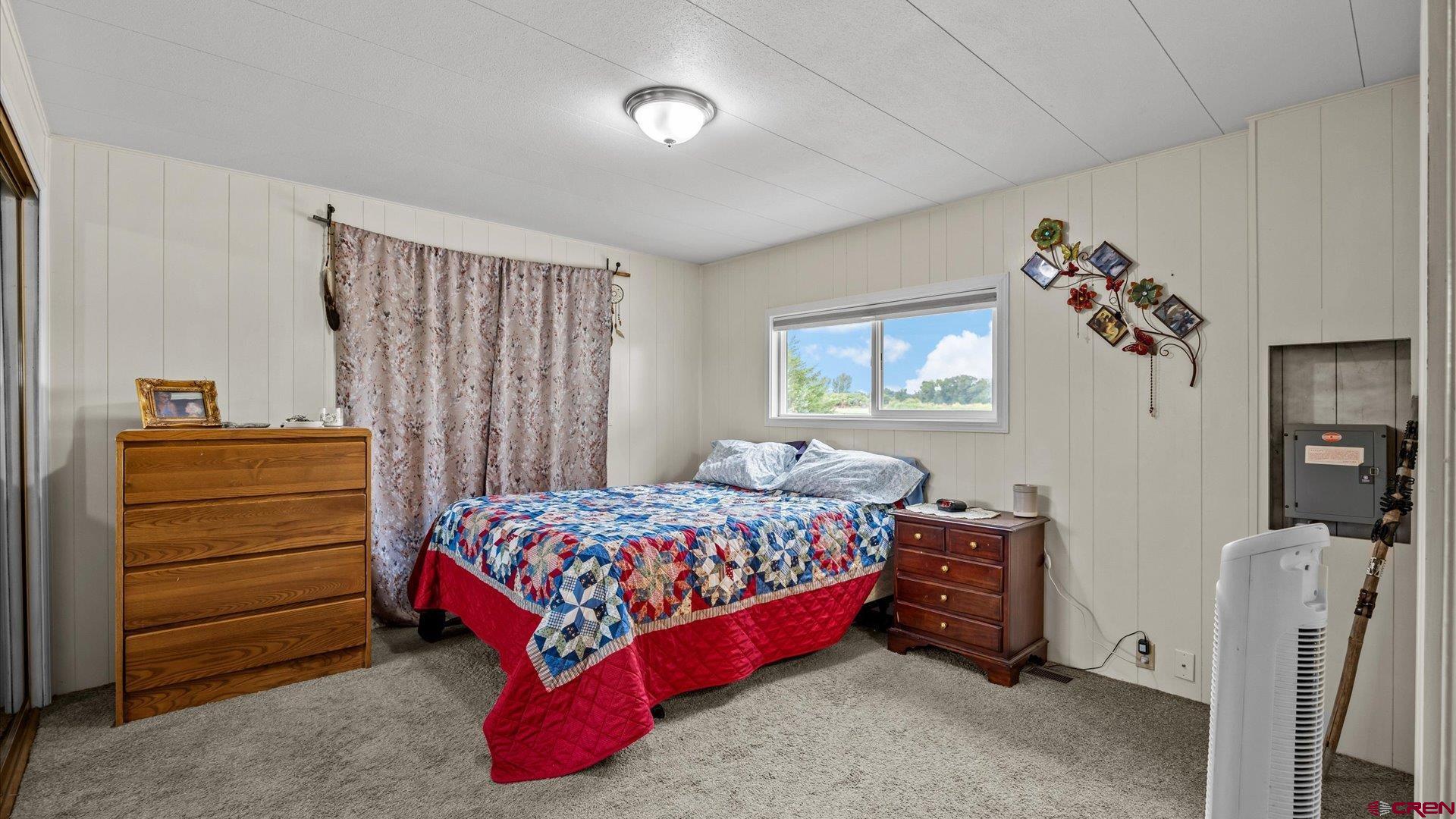 14860 Deer Run Road Delta, CO 81416 - Photo 19 of 33 a bedroom with a bed and a chandelier