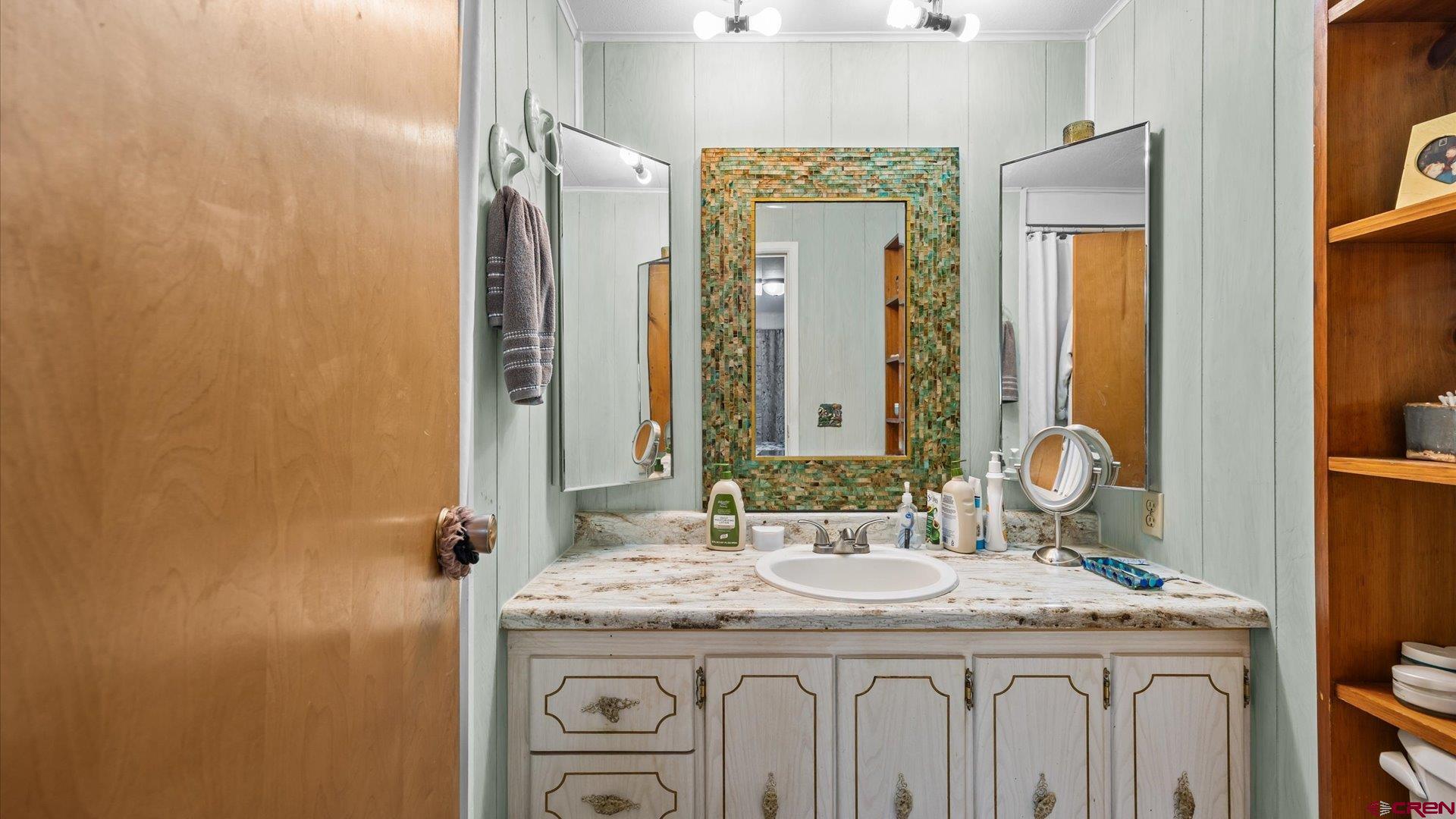 14860 Deer Run Road Delta, CO 81416 - Photo 21 of 33 a bathroom with a granite countertop sink a mirror and a shower