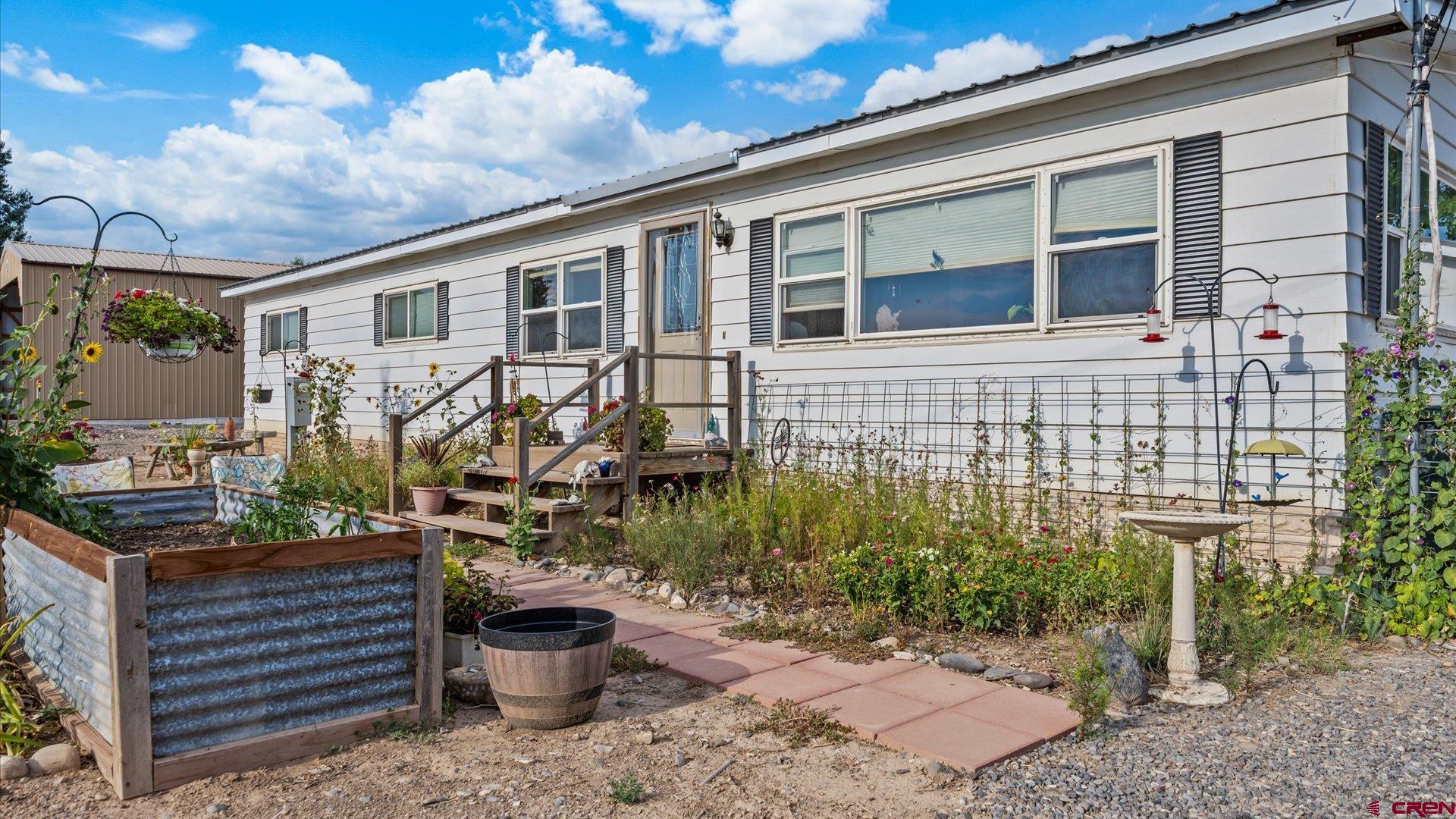 14860 Deer Run Road Delta, CO 81416 - Photo 8 of 33 a front view of a house with garden and plants
