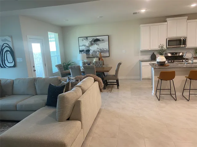 a living room with furniture a flat screen tv and a window