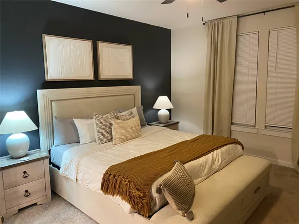 a bedroom with a bed and window with lamp