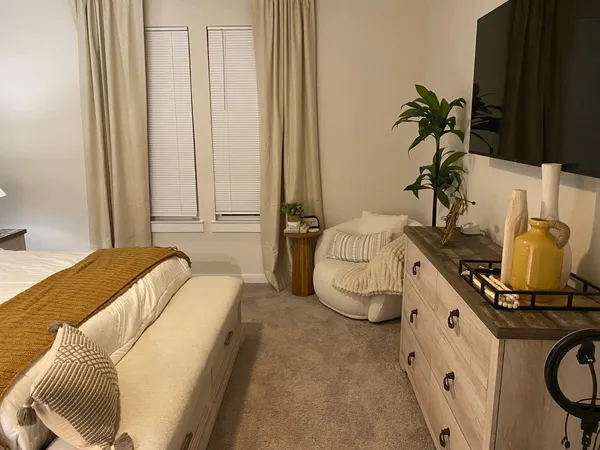 a bedroom with a bed a couch and potted plant