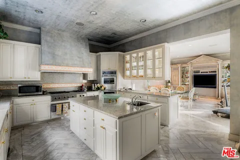 a kitchen with stainless steel appliances granite countertop a sink stove and cabinets