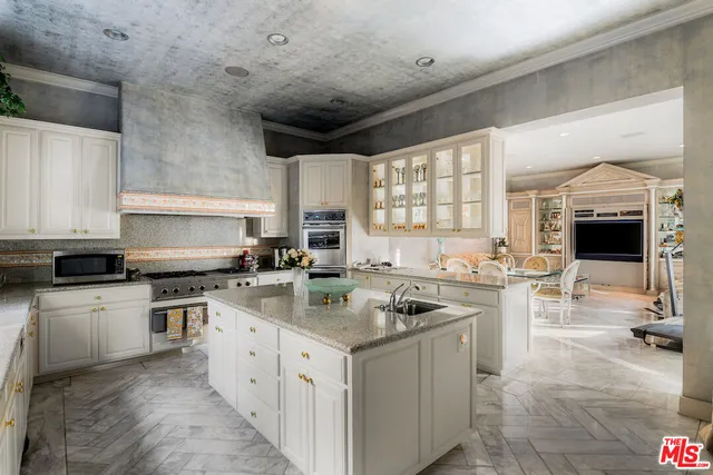 a kitchen with stainless steel appliances granite countertop a sink stove and cabinets