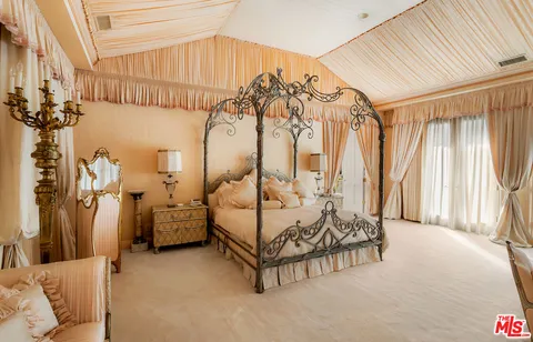 a spacious bedroom with a bed and a chandelier