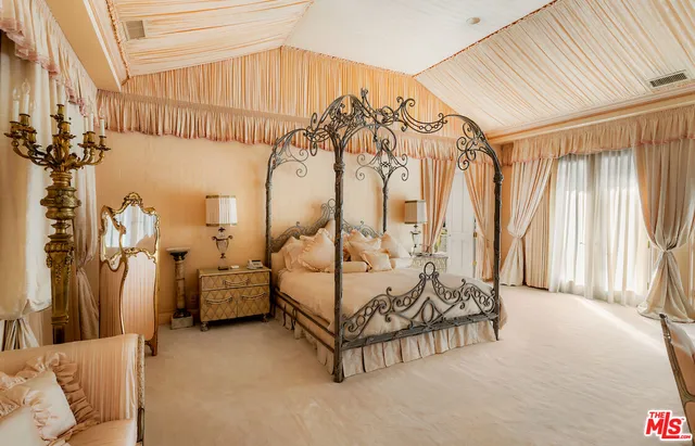 a spacious bedroom with a bed and a chandelier