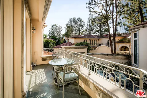 a balcony with table and chairs