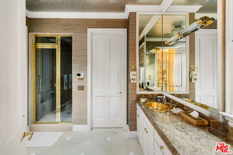a bathroom with a granite countertop tub sink and mirror