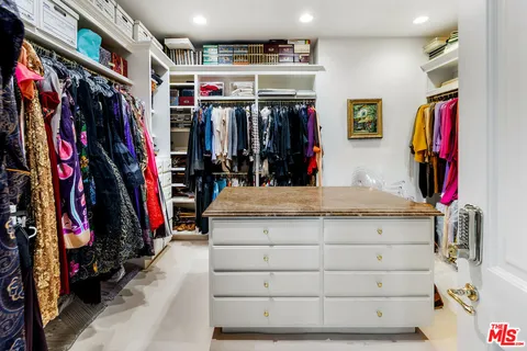 a view of walk in closet with clothes