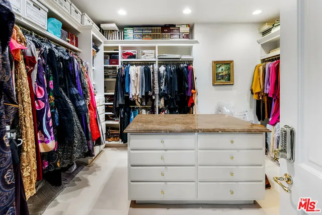 a view of walk in closet with clothes