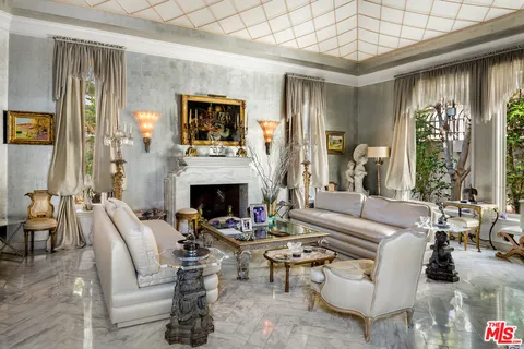 a living room with furniture a large window and a fireplace