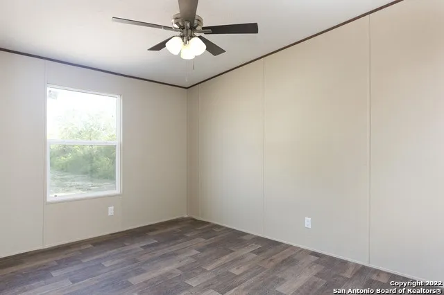 an empty room with a window and a fan