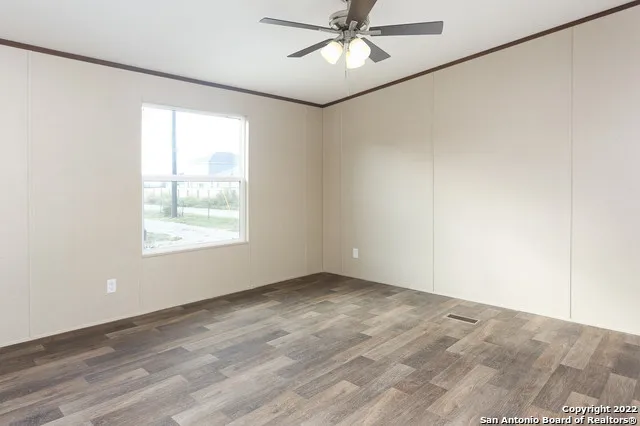 an empty room with a window and a fan