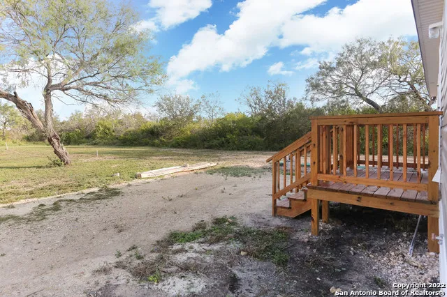 a view of a deck with a yard and wooden fence