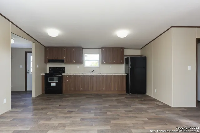 a kitchen with stainless steel appliances kitchen island granite countertop a refrigerator and a stove top oven