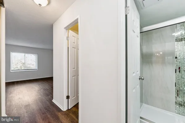 a view of a hallway with wooden floor and closet