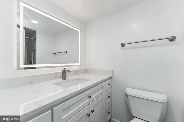 a bathroom with a sink a toilet and a mirror