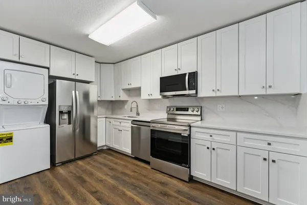 a kitchen with cabinets stainless steel appliances and a counter space